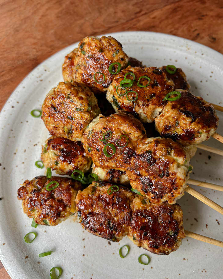 Close up of Tsukune, grilled Japanese meatballs on skewers, plated.
