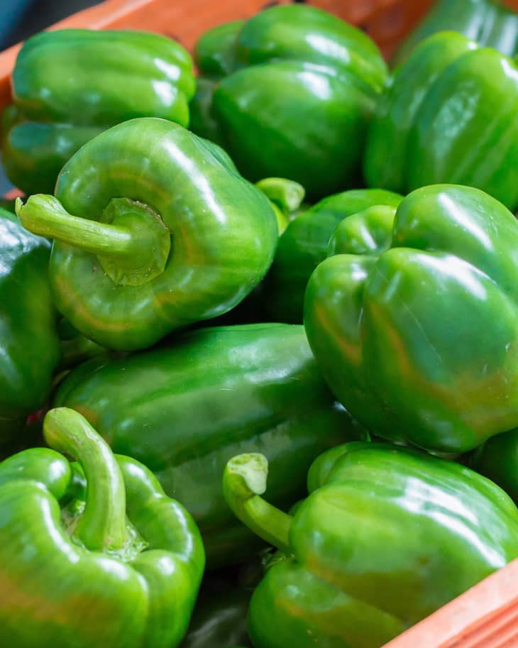 green bell peppers in an orange garden container