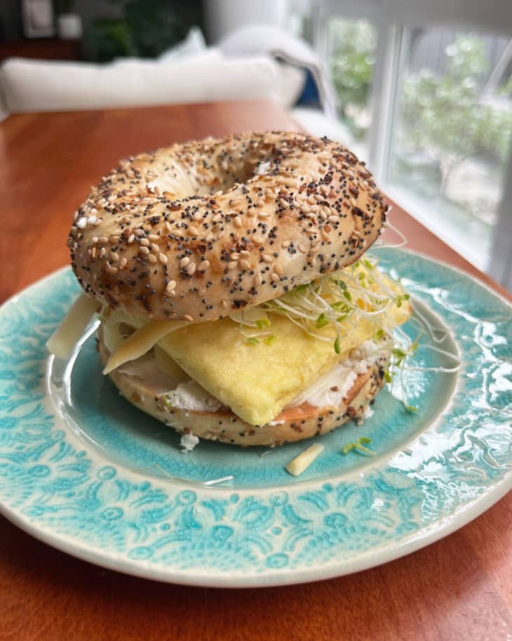 just egg folded egg patty on a bagel breakfast sandwich, turquoise plate