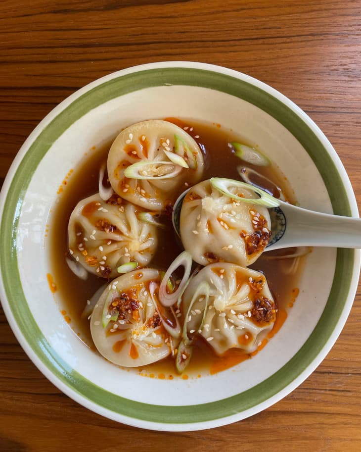 Bowl of Trader Joe's soup dumplings topped with chili sauce.