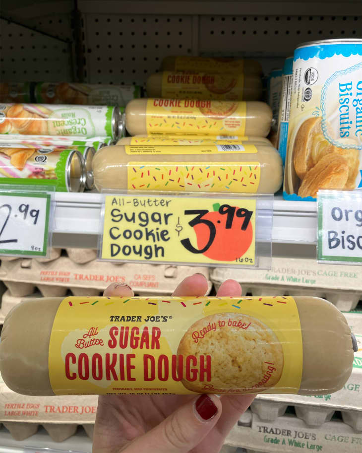Someone holding up container of sugar cookie dough in store.