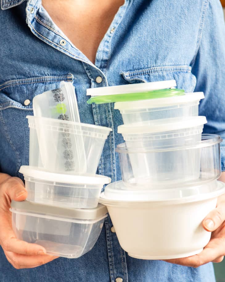 Someone holding multiple food storage containers.