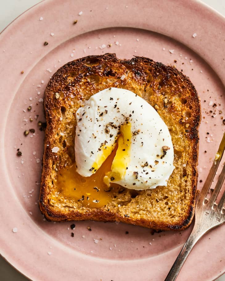 Plated poached egg on toast with salt and pepper.