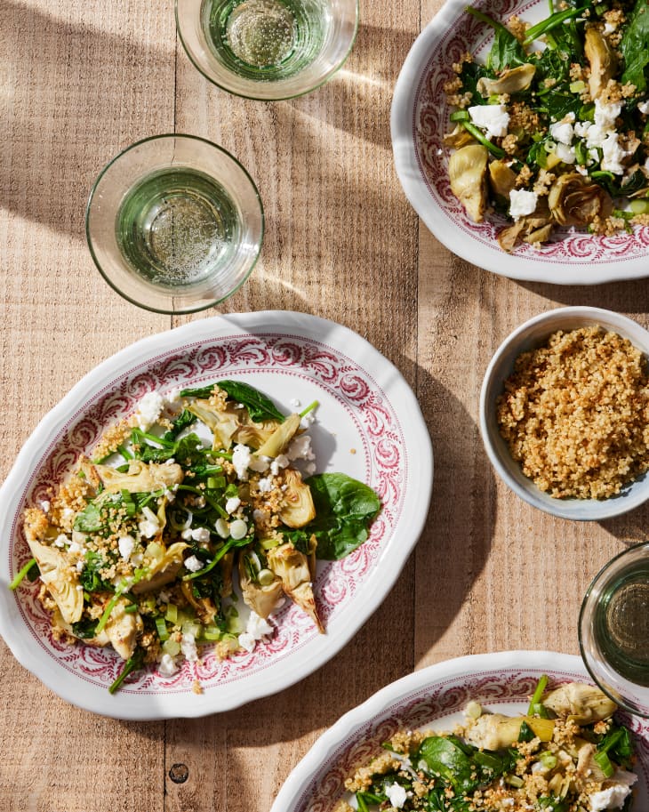 Warm Spinach-Artichoke Salad with Quinoa Crunchies on table.