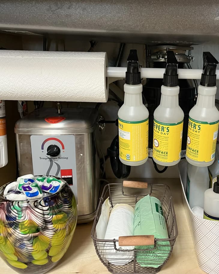 cleaning products, paper towels, hanging on tension rod under sink