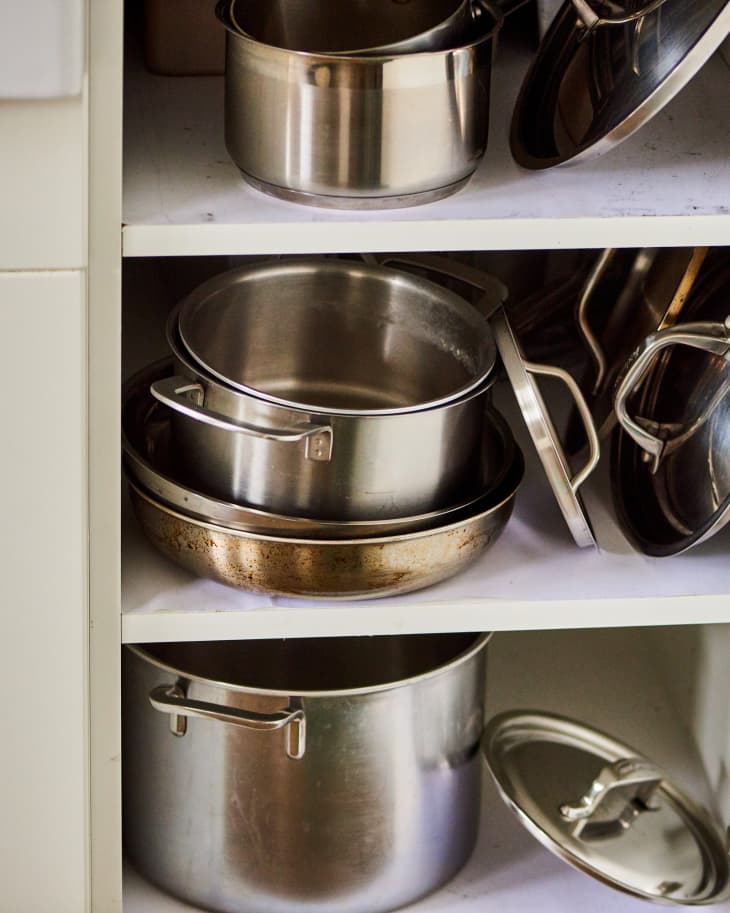 Pots and pans with lids in cabinet