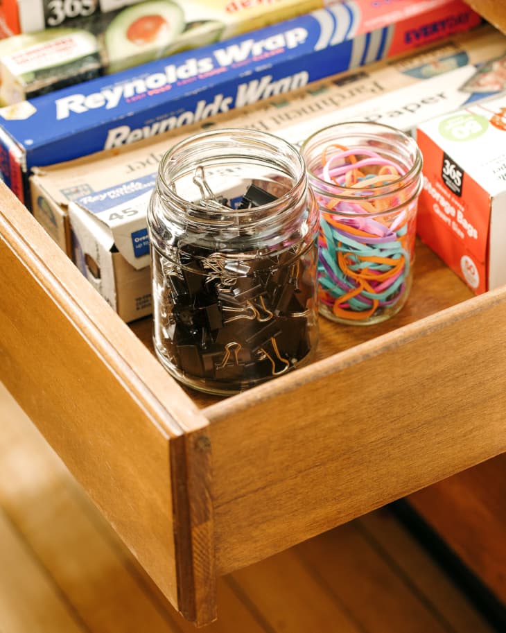 Binder clips and rubber bands organized in pickle jar.