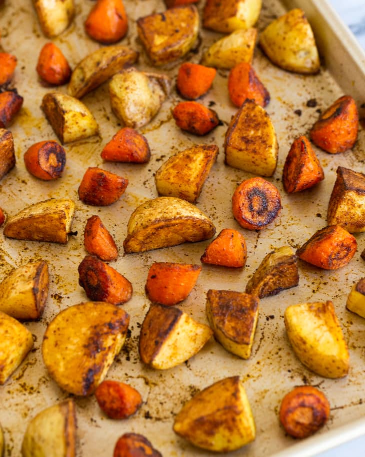 Roasted potatoes and carrots on a platter, cut into roughly 1 inch chunks