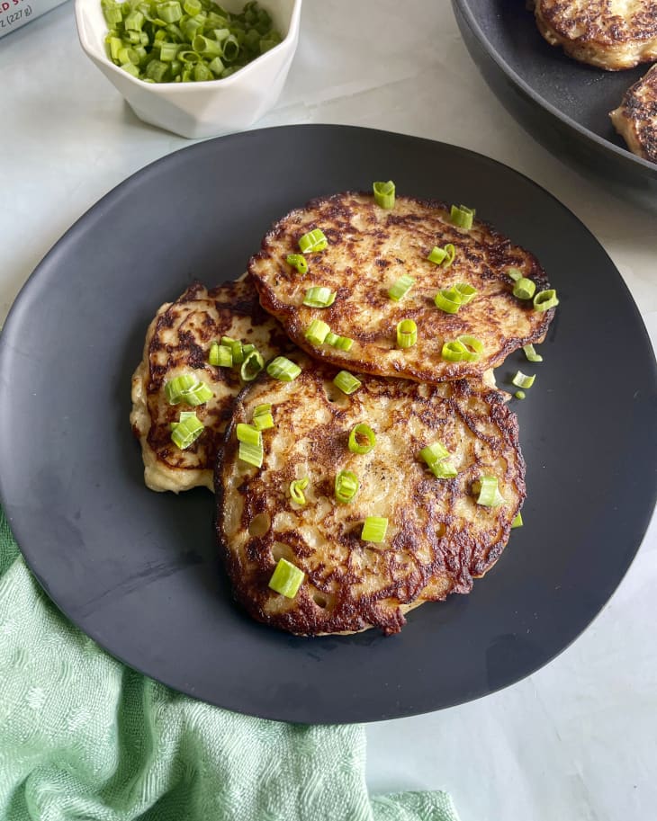boxty (Irish potato pancake)  on a gray plate with minced green onions on top, and a green napkin at the bottom of the frame below the plate.