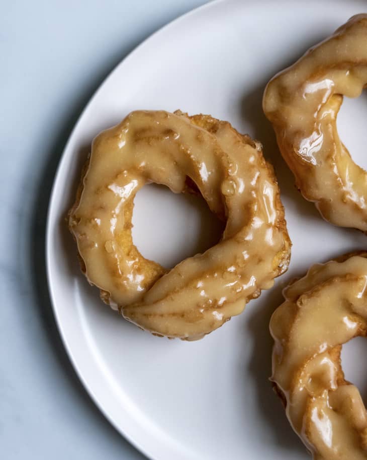 three glazed crullers on a plate