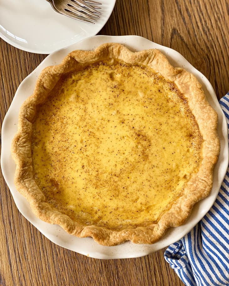 A slice of custard pie (custard pie commonly refers to a plain mixture of milk, eggs, sugar, salt, vanilla extract and sometimes nutmeg combined with a pie crust)