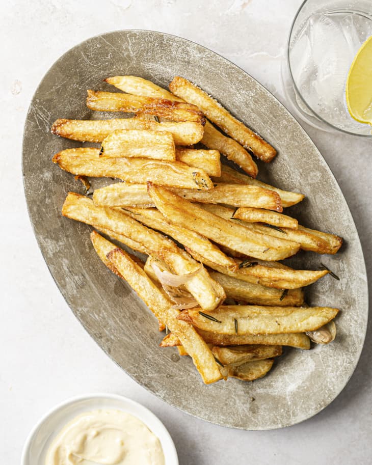 Pomme Frites (french fries) on a silver plate, with a small white bowl of mayo on the side