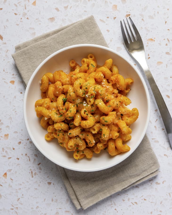 cavatappi noodles with pumpkin sauce,  in a white bowl