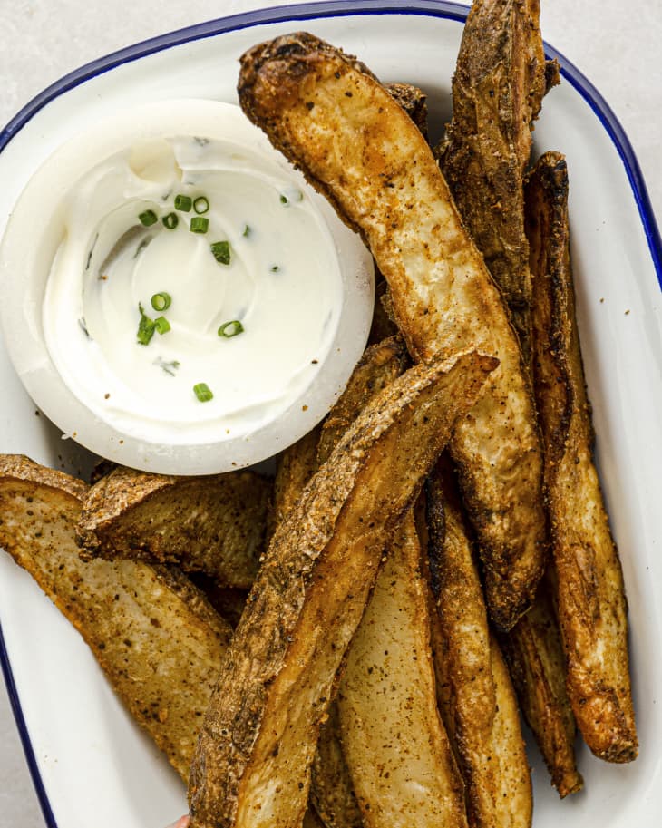 Air Fryer Potato wedges on a plate with white dipping sauce