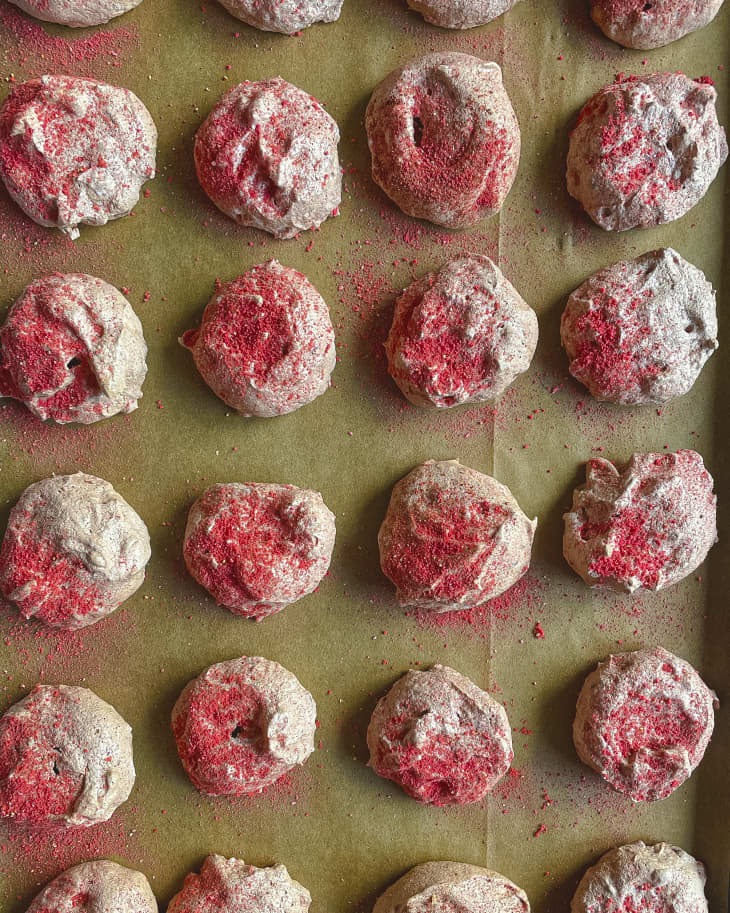chocolate Meringue cookies with red powdered sugar laid out a baking sheet