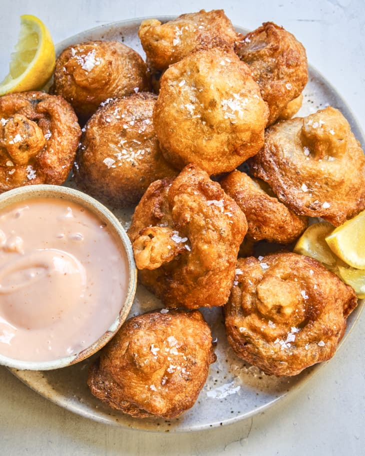 Fried Mushrooms on a platter with a creamy sauce on the side.