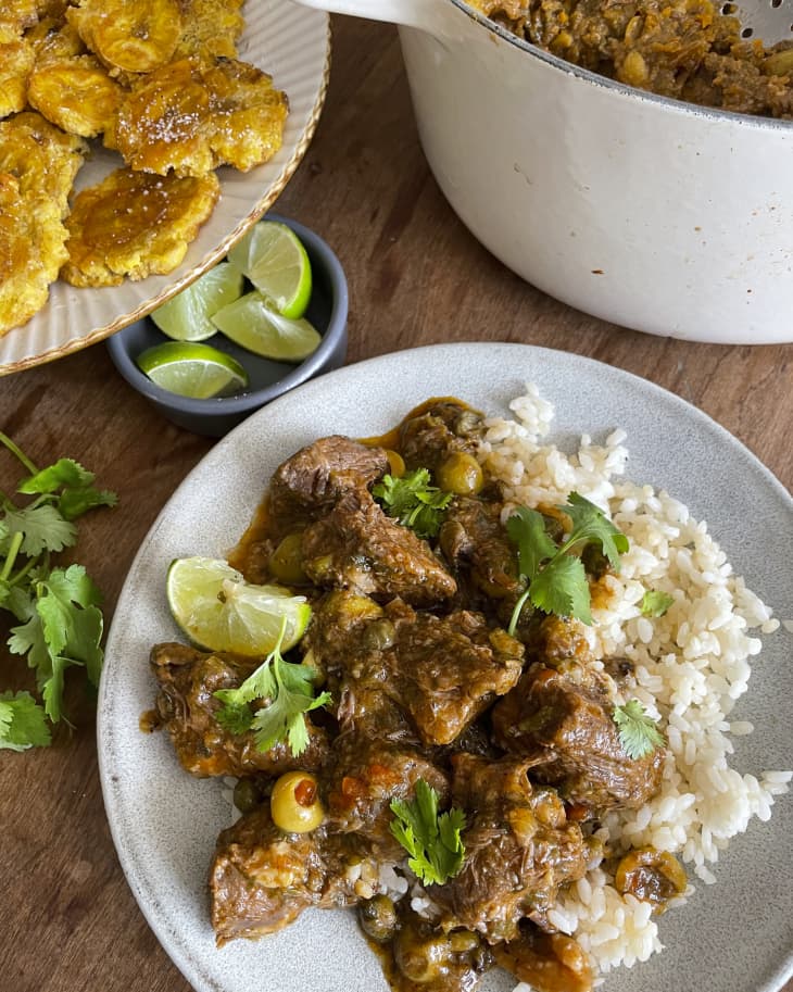 Carne guisada (beef stew made from beef chuck or round that is slowly cooked at low heat until tender) on a white plate with white rice.