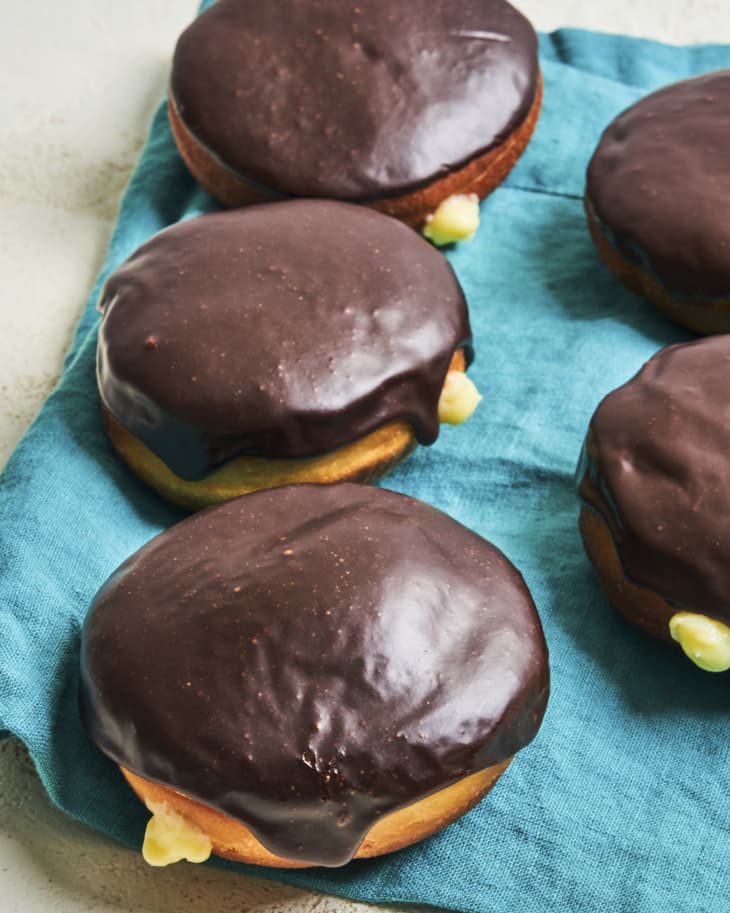boston cream donuts with chocolate icing,  on a green cloth napkin