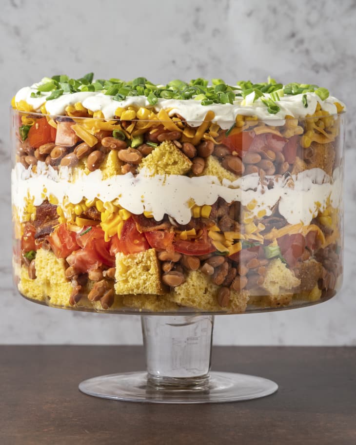 layered cornbread salad with beans, sour cream, tomatoes and chives