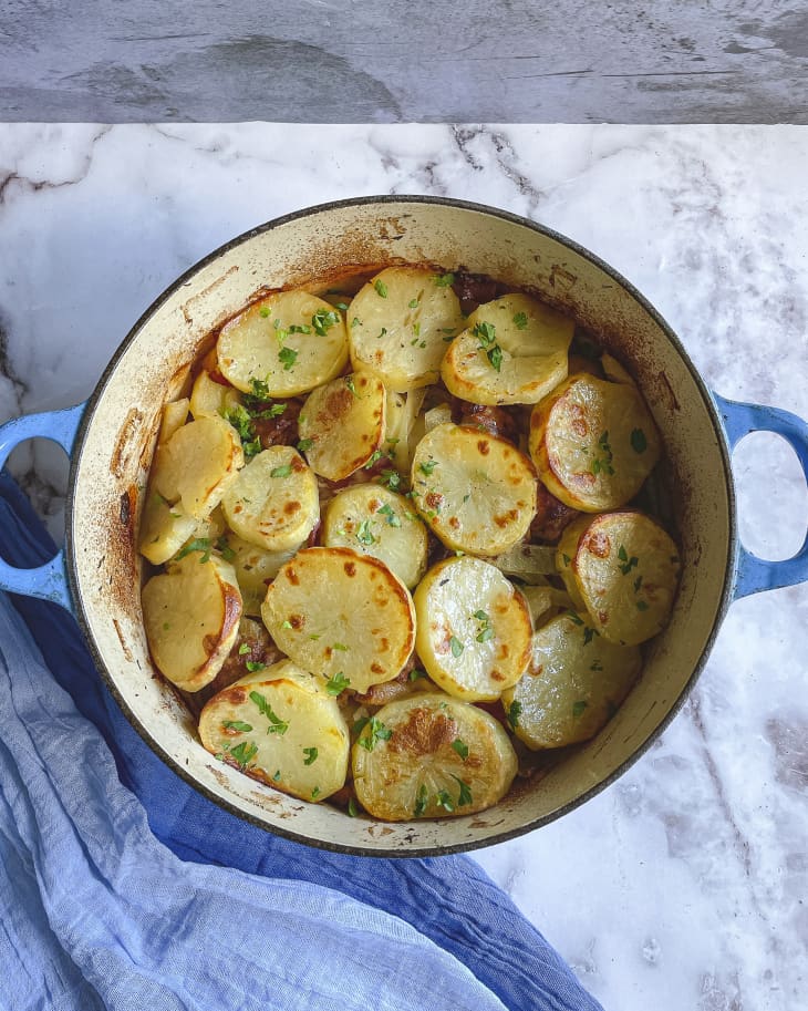 sauteed potatoes in a pot on a marble background