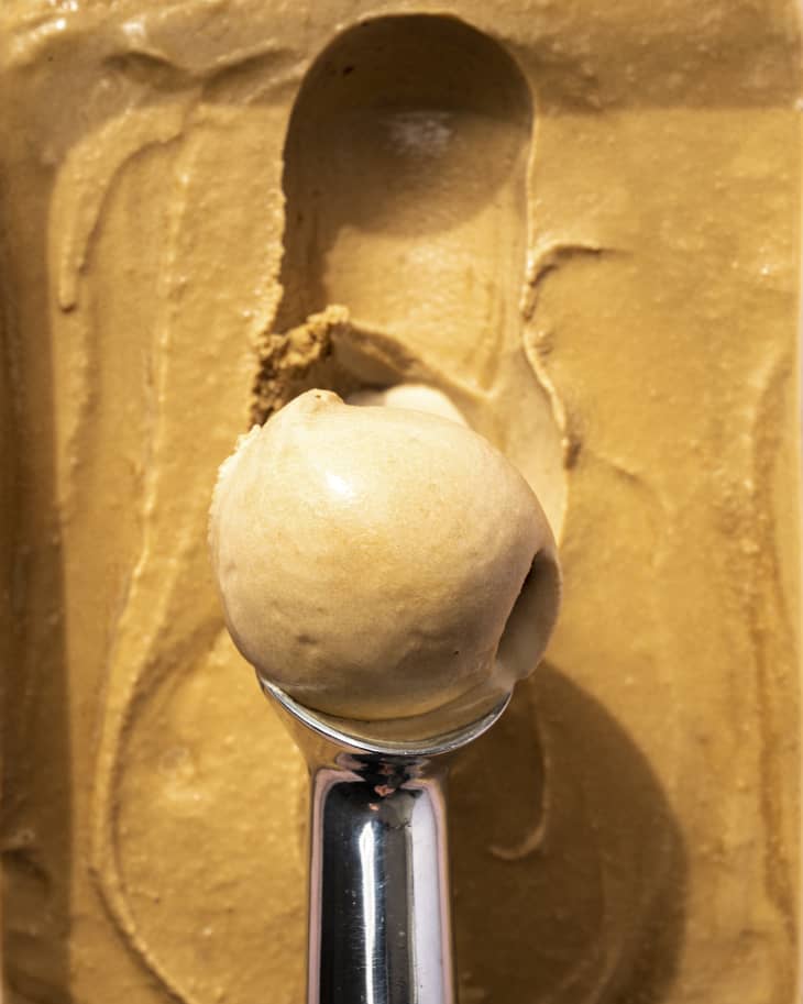 coffee ice cream being scooped with a silver ice cream scooper