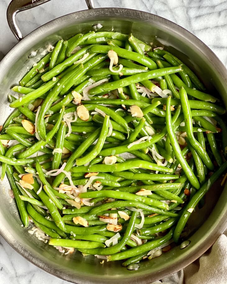 green beans (almondine) with slice almonds in a metal sautee pan
