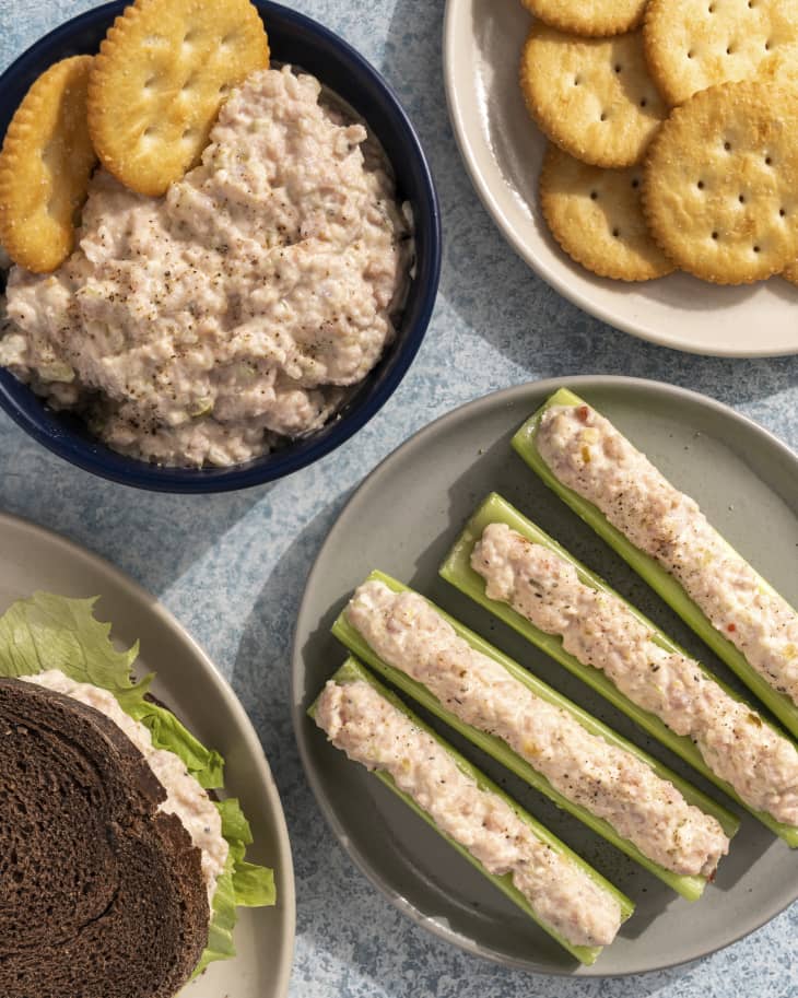 ham salad in a bowl with crackers, a gray plate with celery slices with ham salad on top, and a plate with round crackers