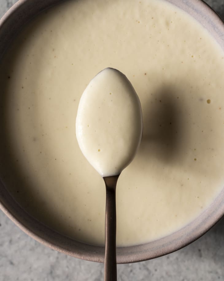 Soubise (an onion sauce thickened with Béchamel sauce, pounded cooked rice, or cream) being lifted up by a spoon