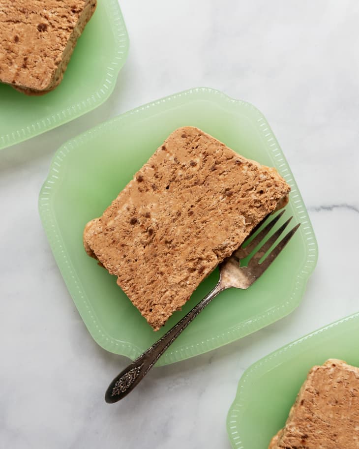 slices of Semifreddo (a classic Italian frozen dessert that's halfway between ice cream and mousse) on square, pale green plates with a fork next to it.
