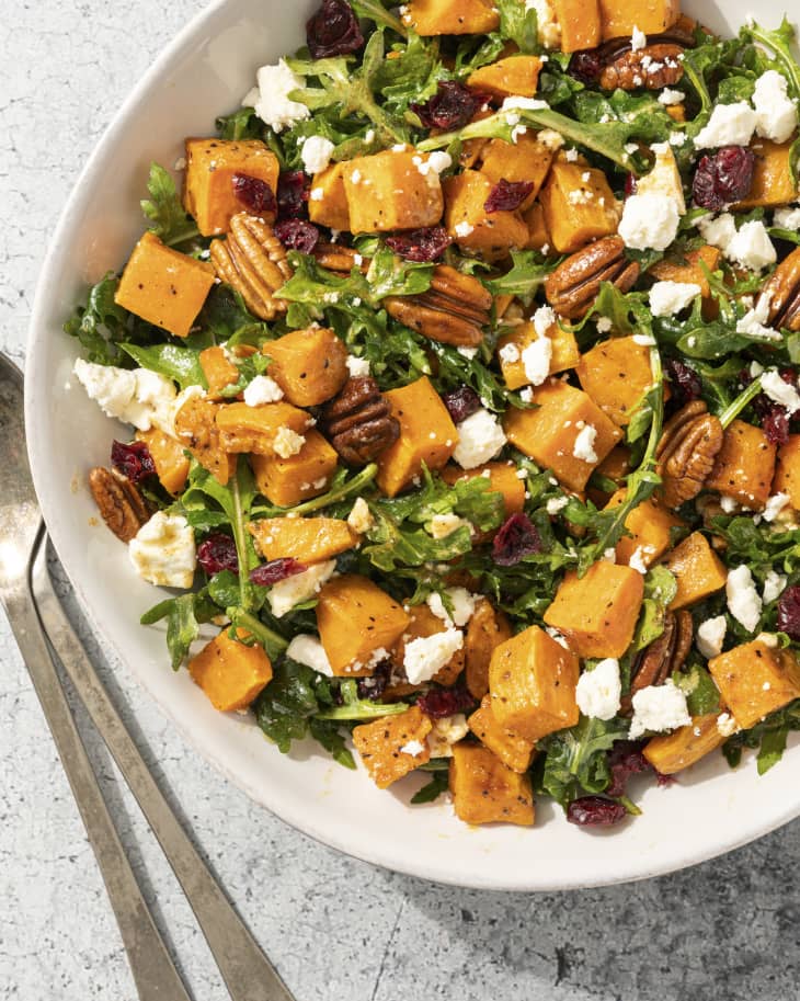 a sweet potato salad tossed with arugula, cranberries, pecans and crumbled white cheese