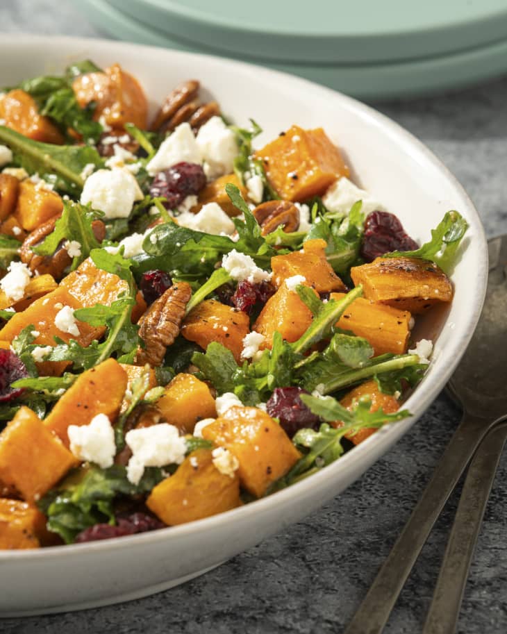 a sweet potato salad tossed with arugula, cranberries, pecans and crumbled white cheese
