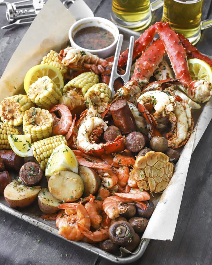 A platter of boiled seafood (crab legs, shrimp, sausage and corn on the cob)
