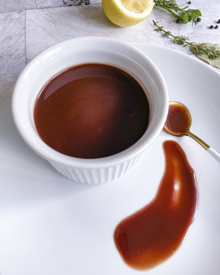 A photo of a ramekin of Bordelaise sauce (a classic French sauce named after the Bordeaux region of France, which is famous for its wine. The sauce is made with dry red wine, bone marrow, butter, shallots and sauce demi-glace)
