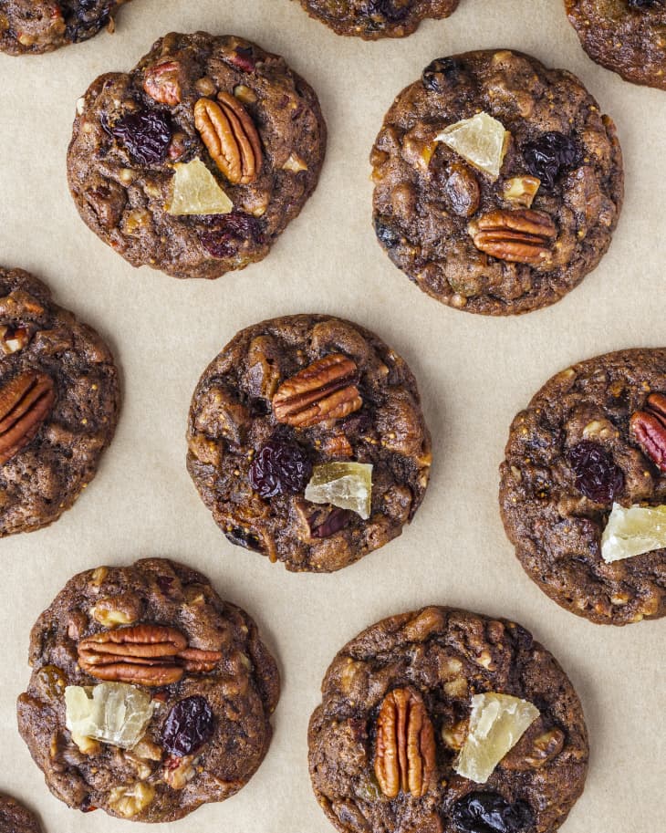 A photo of fruitcake cookies, topped with pecans and dried fruit.
