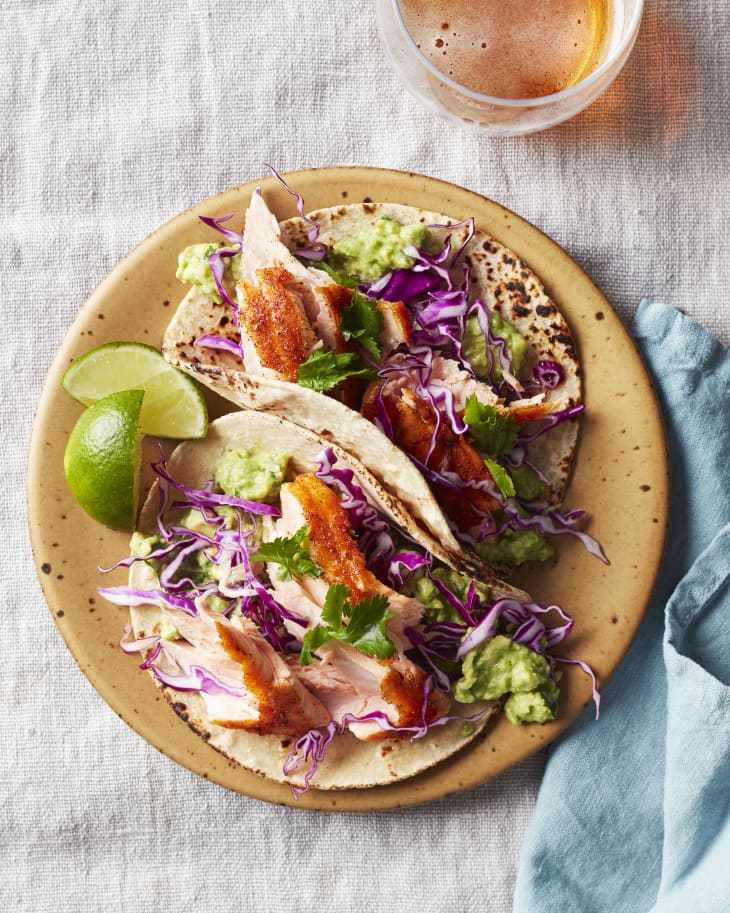 Two tacos on a plate at the dinner table.