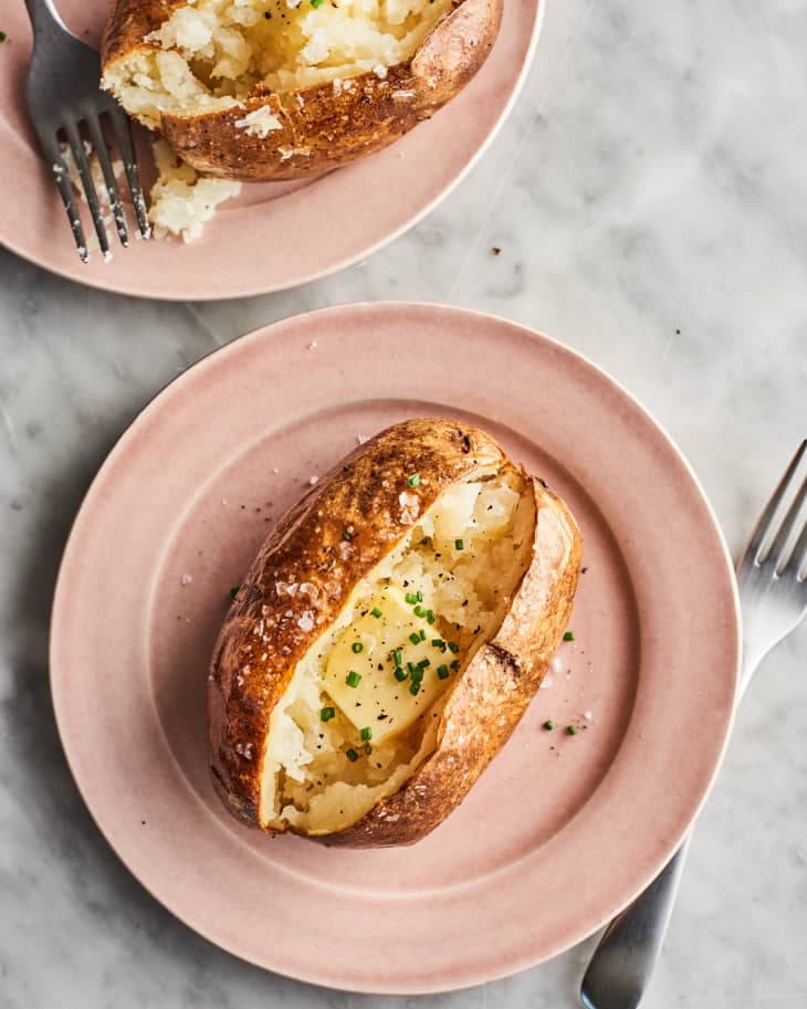 baked potato on a plate with butter and chives