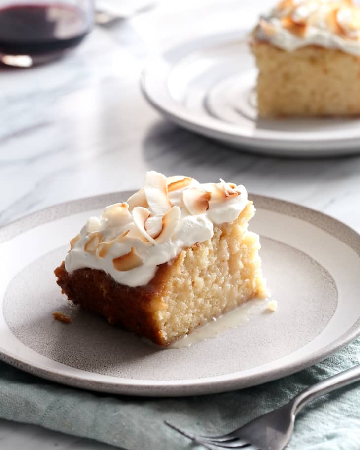 Slices of tres leches cake sit on plates.