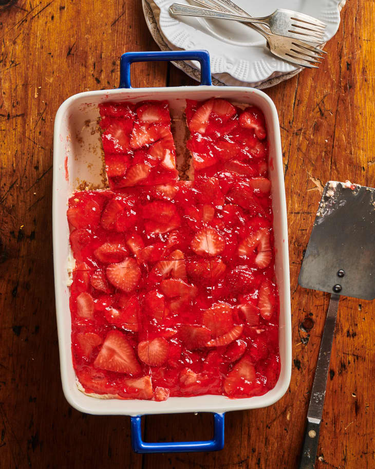 strawberry pretzel salad in baking sheet with a slice