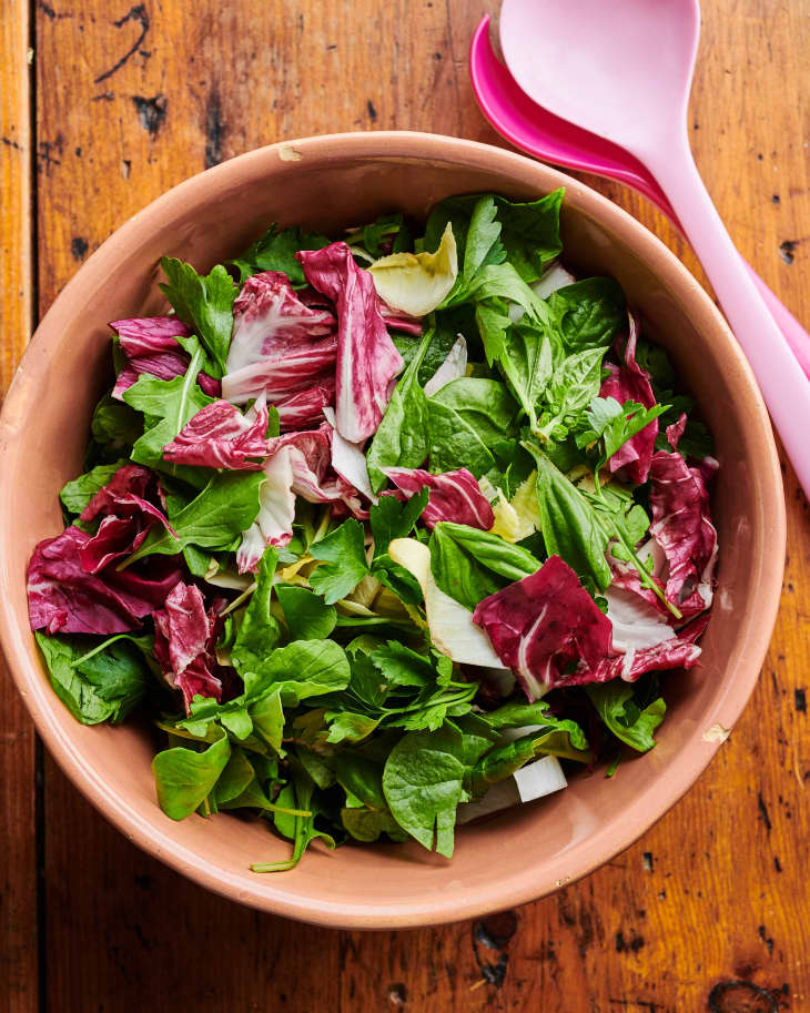A large bowl of spring mixed greens sits on a table.
