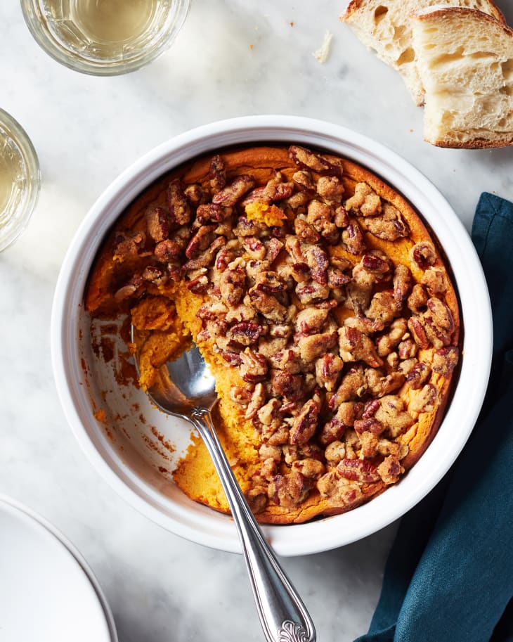 Serving spoon inside sweet potato souffle dish.