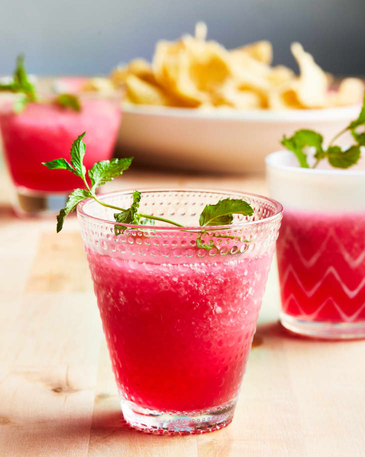 Quick frozen margarita topped with fresh mint in pretty tumbler glass.