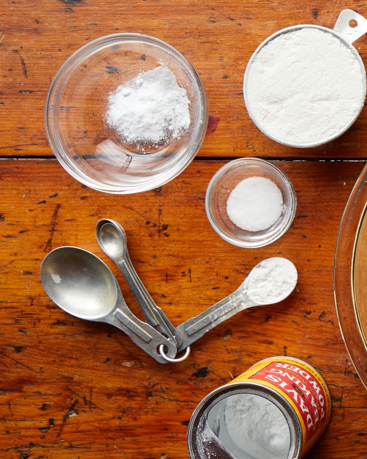 One step in making southern hushpuppies: flour, baking powder being measured out over wood surface