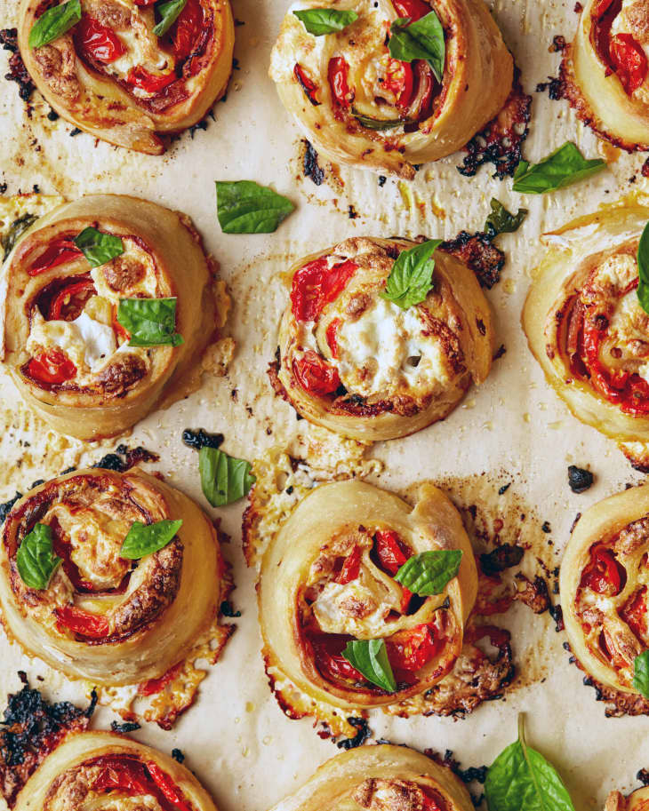 Fancy pizza rolls on parchment paper lined baking sheet.