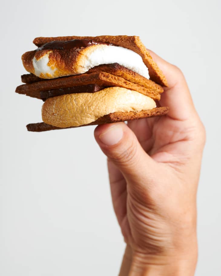 A hand holds two s'mores.