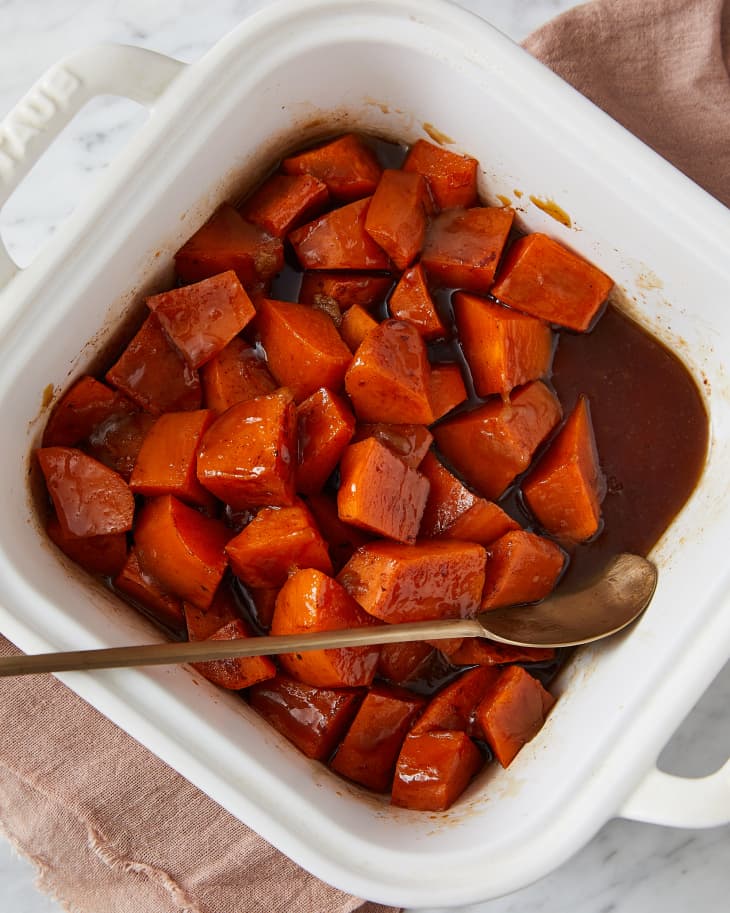 Southern candied yams in baking dish with spoon on side.