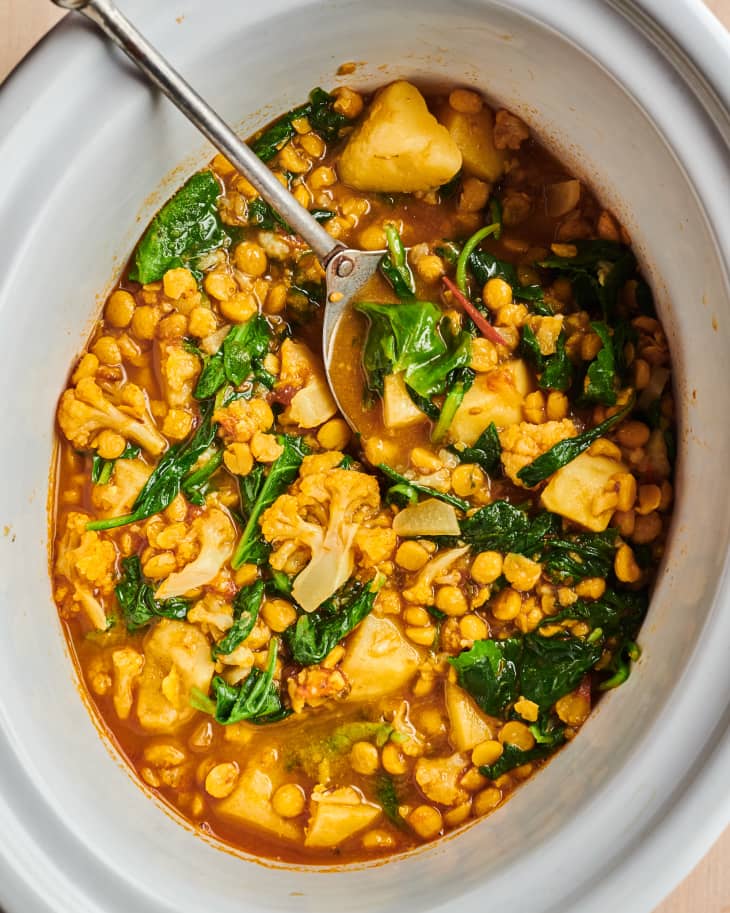 Chickpeas with vegetables Pahari Dal in slow cooker with serving spoon on side.