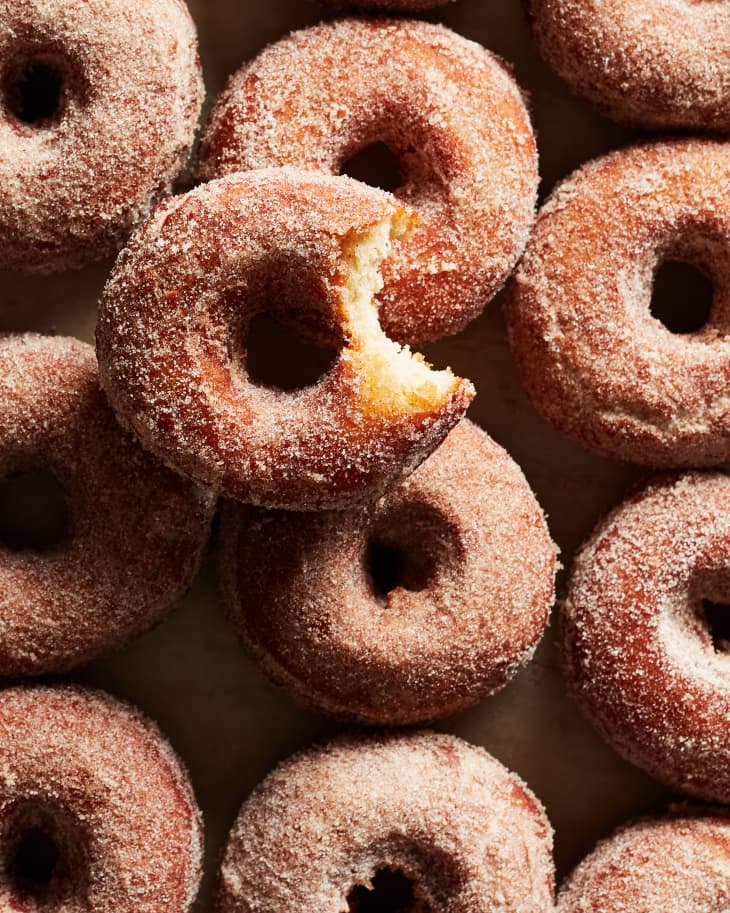 Apple cider donuts with one bitten.