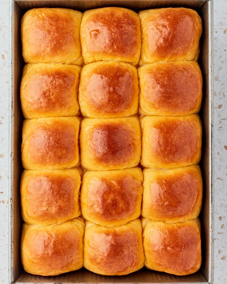 Dinner rolls sit in neat rows in the baking pan