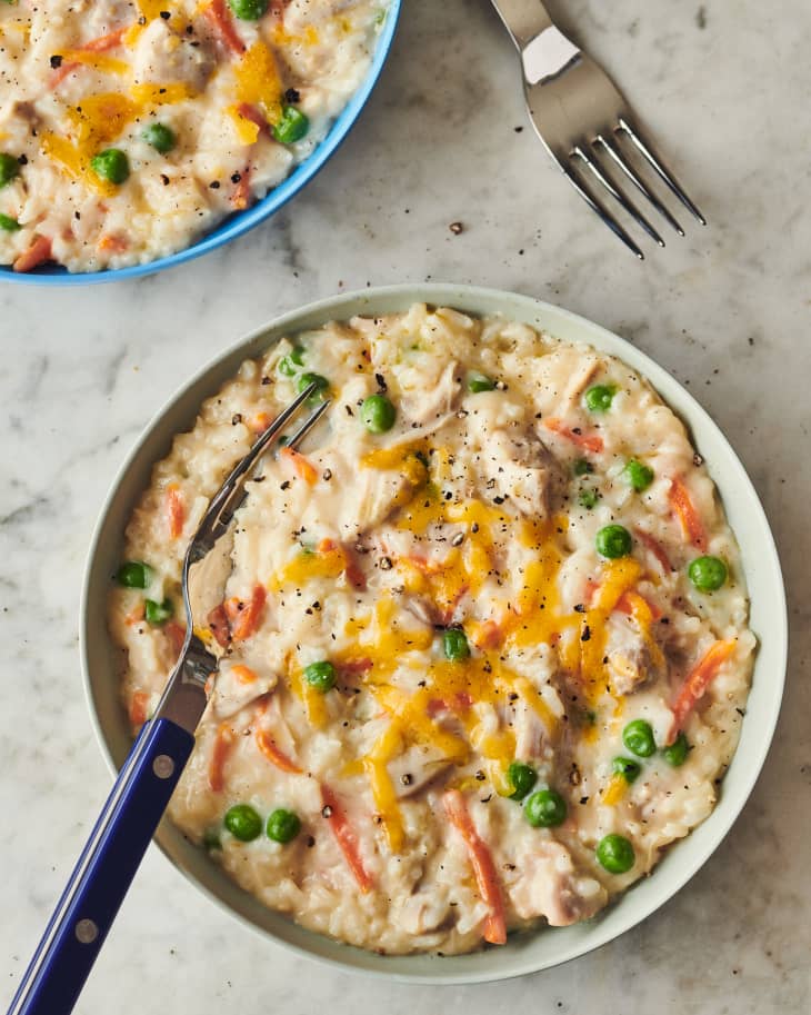 chicken and rice served in a bowl with a metal spoon