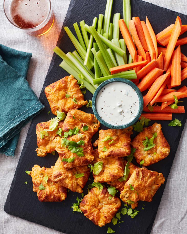 buffalo chicken bites on a platter next to celery, carrots, and ranch